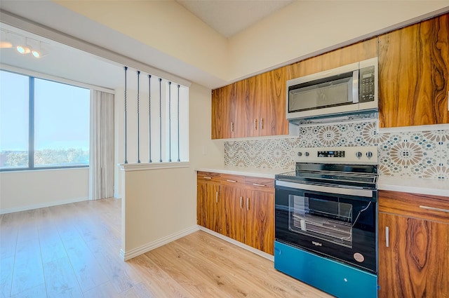 kitchen featuring light hardwood / wood-style floors, backsplash, and appliances with stainless steel finishes