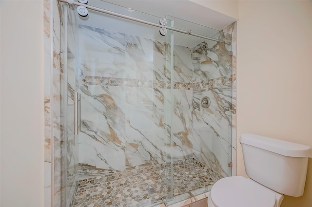 bathroom featuring an enclosed shower and toilet