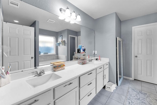 bathroom featuring tile patterned floors, a tub to relax in, and vanity