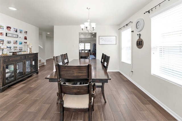 dining room with dark hardwood / wood-style flooring and a notable chandelier