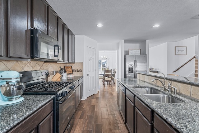 kitchen featuring dark stone counters, sink, decorative backsplash, and black appliances