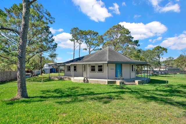 rear view of property featuring a lawn and a porch