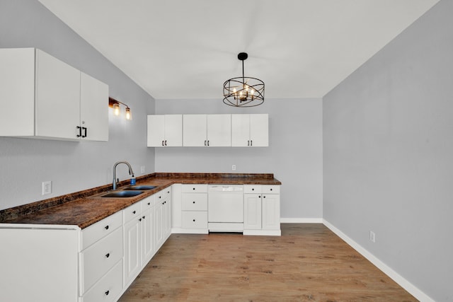 kitchen featuring sink, dishwasher, light hardwood / wood-style floors, white cabinetry, and hanging light fixtures