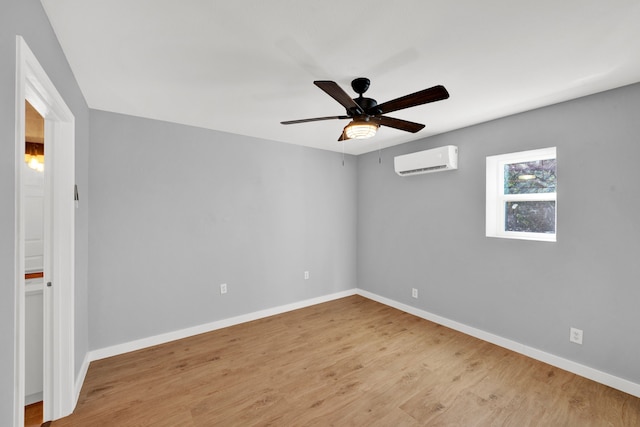 spare room featuring ceiling fan, light wood-type flooring, and a wall mounted AC