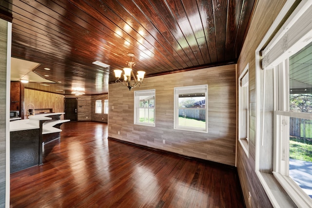 living room featuring a chandelier, wooden walls, dark hardwood / wood-style flooring, and wood ceiling