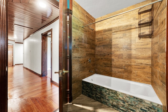 bathroom with tiled shower / bath combo, wood-type flooring, and ornamental molding