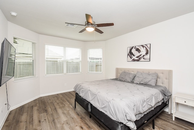 bedroom featuring multiple windows, ceiling fan, and wood-type flooring