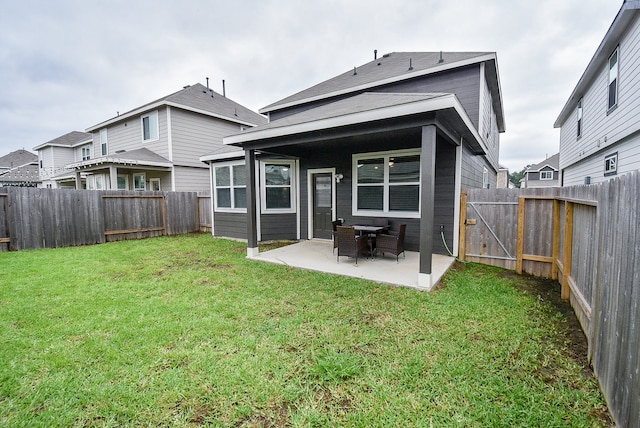 back of house with a yard and a patio