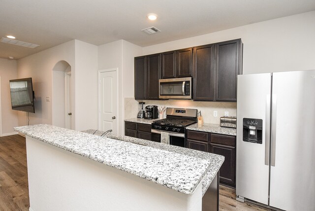 kitchen with sink, a center island, stainless steel appliances, and light hardwood / wood-style floors