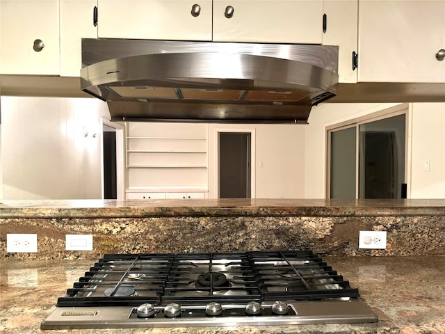 kitchen featuring white cabinetry, stainless steel gas stovetop, stone counters, and ventilation hood