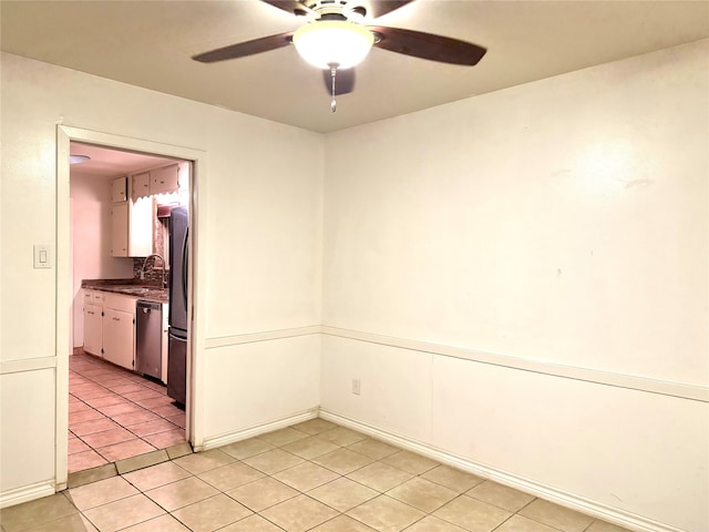 empty room featuring ceiling fan, light tile patterned floors, and sink