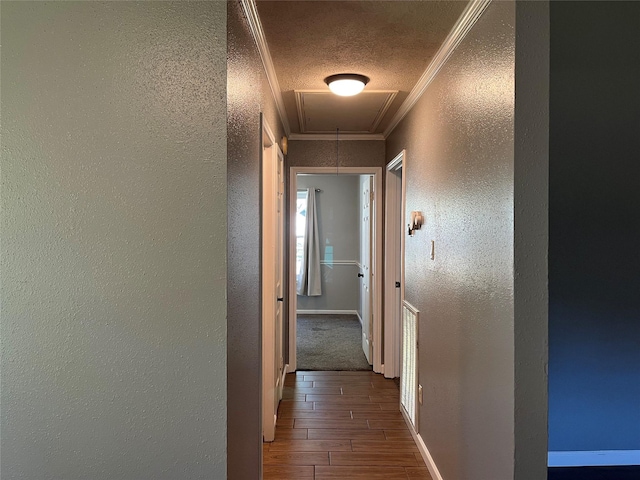 hallway featuring a textured ceiling and ornamental molding