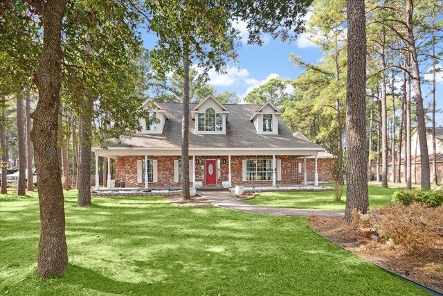 new england style home featuring a front yard and a porch