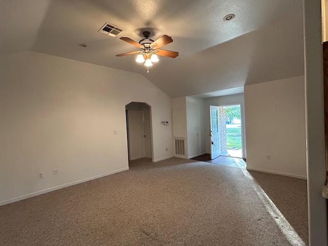 carpeted empty room featuring vaulted ceiling and ceiling fan