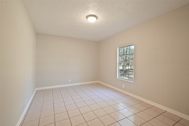 empty room with light tile patterned flooring and a textured ceiling