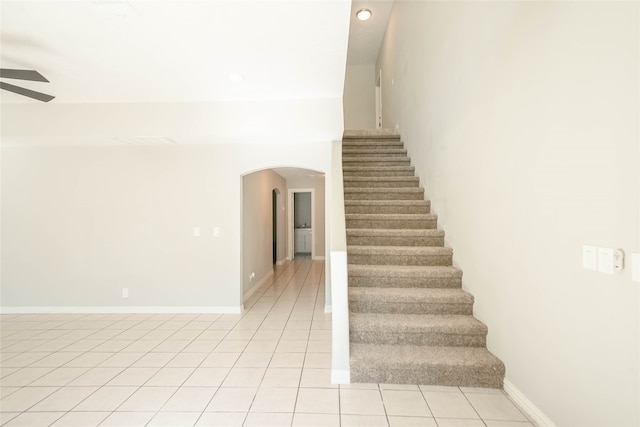 stairs featuring tile patterned flooring and ceiling fan