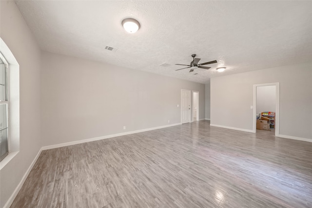 spare room with wood-type flooring, a textured ceiling, and ceiling fan