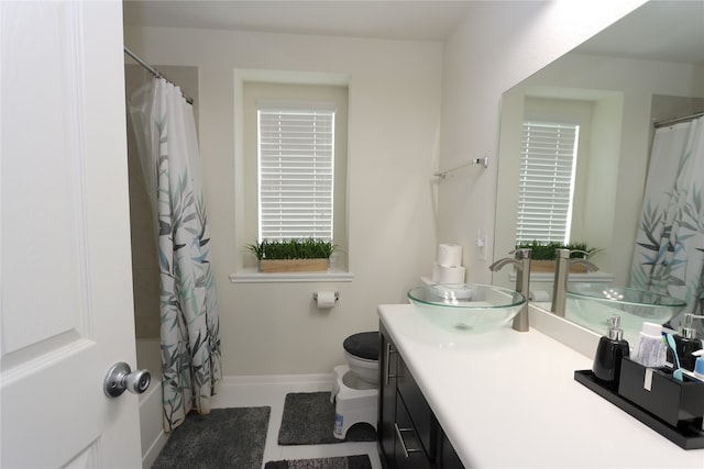 bathroom with a shower with shower curtain, vanity, a healthy amount of sunlight, and toilet