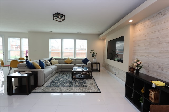 living room with light tile patterned flooring and wooden walls