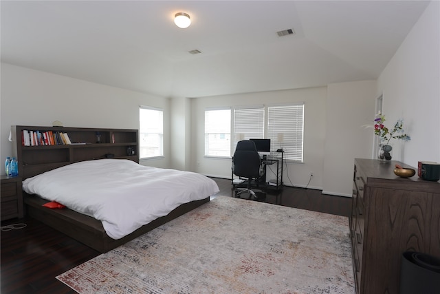 bedroom featuring dark wood-type flooring and vaulted ceiling