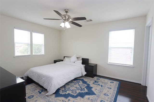 bedroom featuring multiple windows, ceiling fan, and dark wood-type flooring