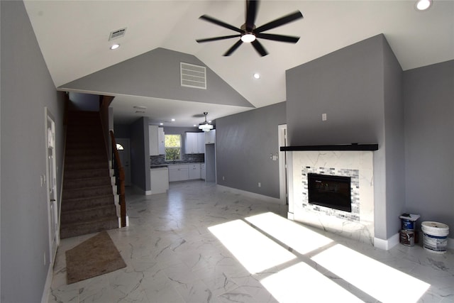 unfurnished living room featuring high vaulted ceiling, ceiling fan, and a tiled fireplace