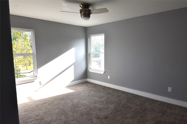 carpeted empty room featuring ceiling fan and a healthy amount of sunlight