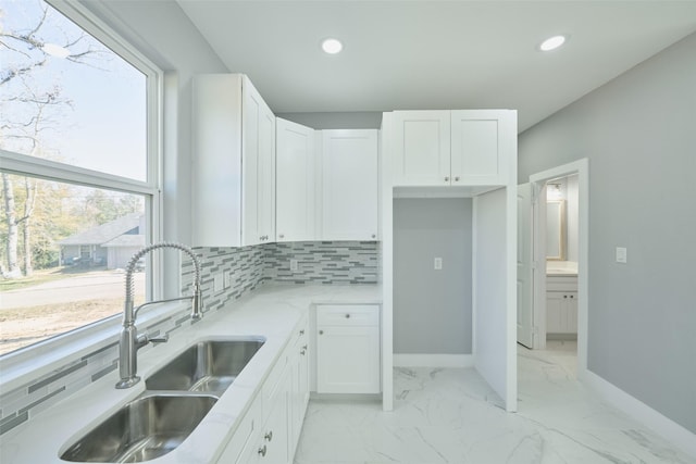 kitchen with tasteful backsplash, sink, and white cabinets