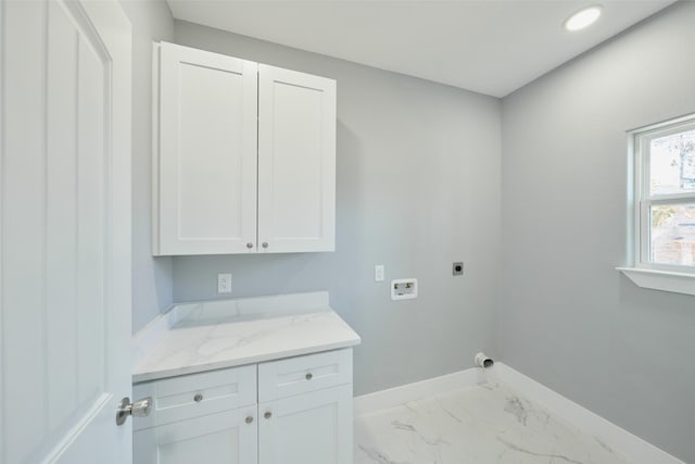 laundry area featuring electric dryer hookup, hookup for a washing machine, and cabinets