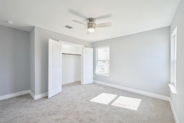 unfurnished bedroom with ceiling fan, light carpet, and a closet