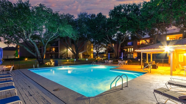 pool at dusk featuring a wooden deck