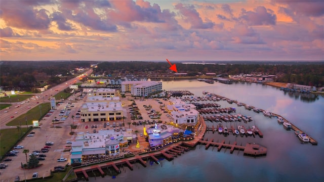 aerial view at dusk featuring a water view