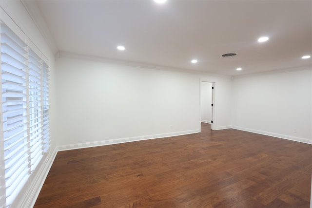 spare room with dark hardwood / wood-style floors and crown molding