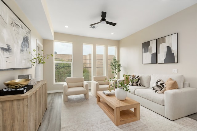 living room with ceiling fan and light hardwood / wood-style flooring