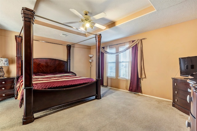 carpeted bedroom with ceiling fan and a textured ceiling