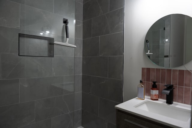 bathroom featuring a tile shower, tasteful backsplash, and vanity