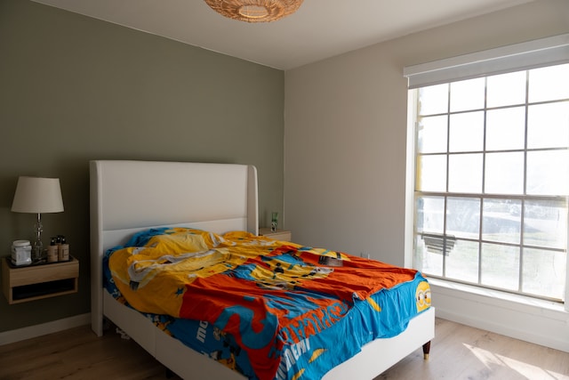 bedroom with hardwood / wood-style floors and multiple windows