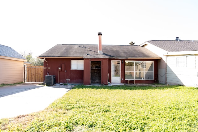 rear view of house with a yard and central AC