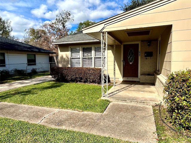 entrance to property with a lawn