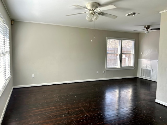 empty room featuring crown molding, plenty of natural light, dark wood-type flooring, and ceiling fan