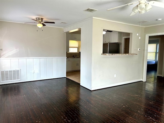 empty room with dark hardwood / wood-style floors, ceiling fan, ornamental molding, and sink