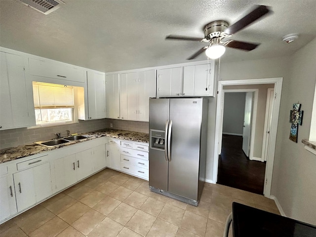 kitchen featuring decorative backsplash, sink, dark stone countertops, stainless steel fridge with ice dispenser, and white cabinetry