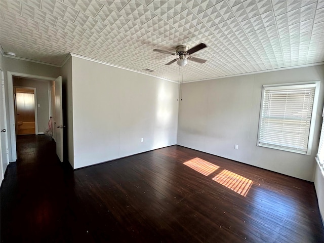 empty room with ceiling fan, dark hardwood / wood-style flooring, and ornamental molding