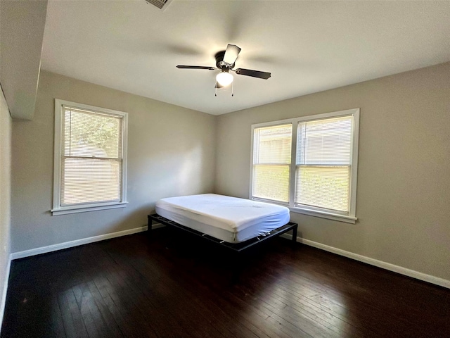 unfurnished bedroom with ceiling fan and dark hardwood / wood-style floors