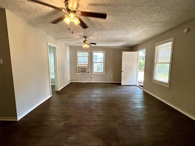 empty room featuring ceiling fan, cooling unit, dark hardwood / wood-style floors, and a textured ceiling