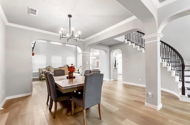 dining room with a chandelier, ornamental molding, and light wood-type flooring