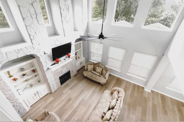 living room with ceiling fan, light hardwood / wood-style floors, and a fireplace