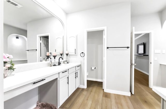 bathroom with vanity, hardwood / wood-style flooring, and toilet