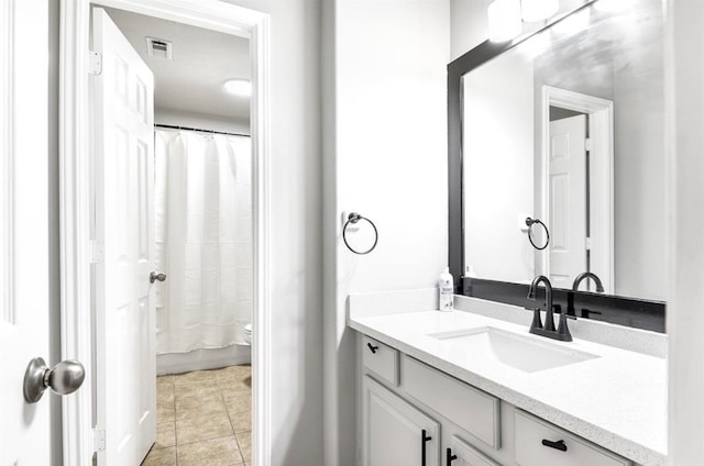 bathroom with tile patterned flooring, vanity, and toilet