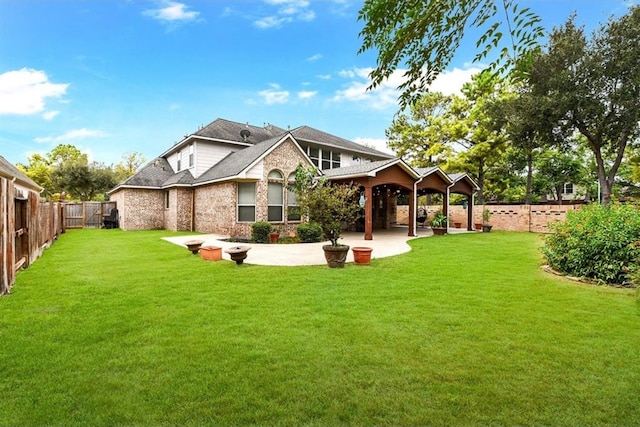 back of house with a yard and a patio